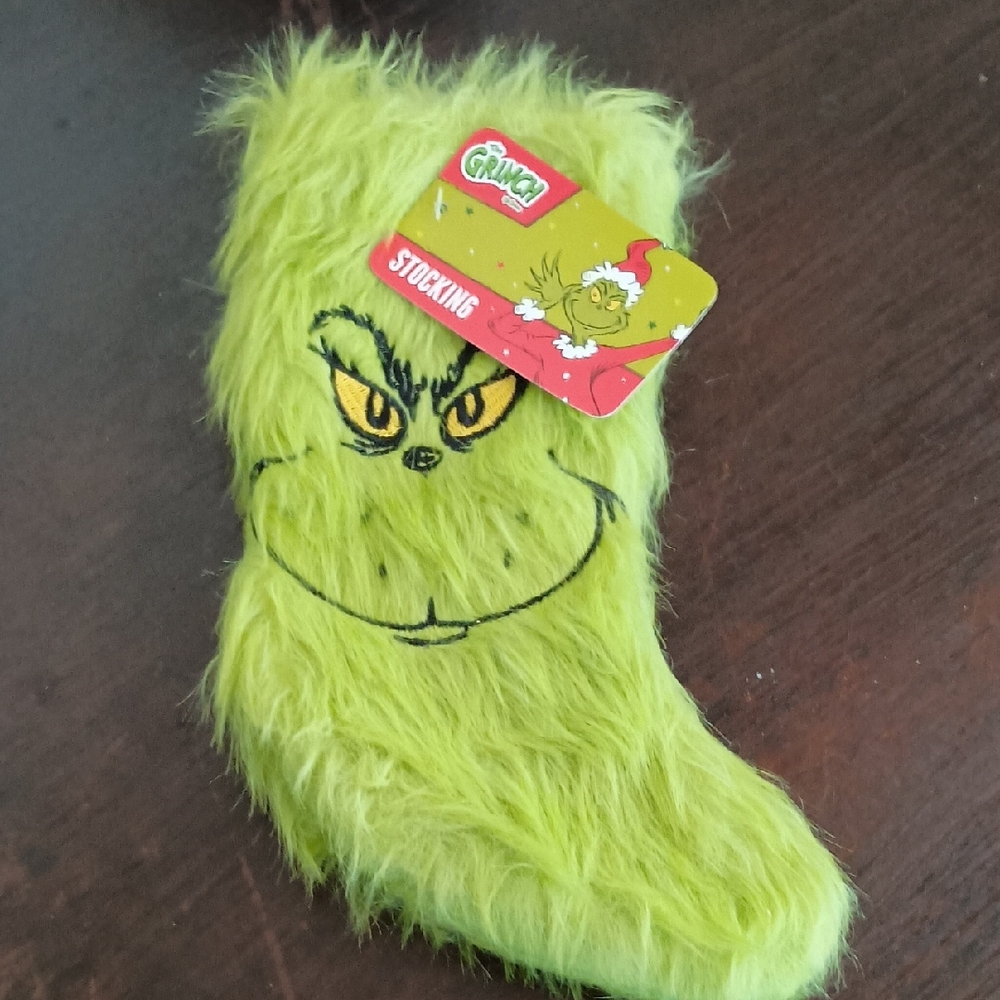 The Grinch Christmas stockings with embroidered smirking faces. 